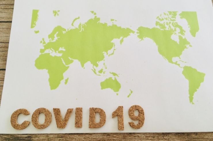 世界地図の上にcovid-19の文字