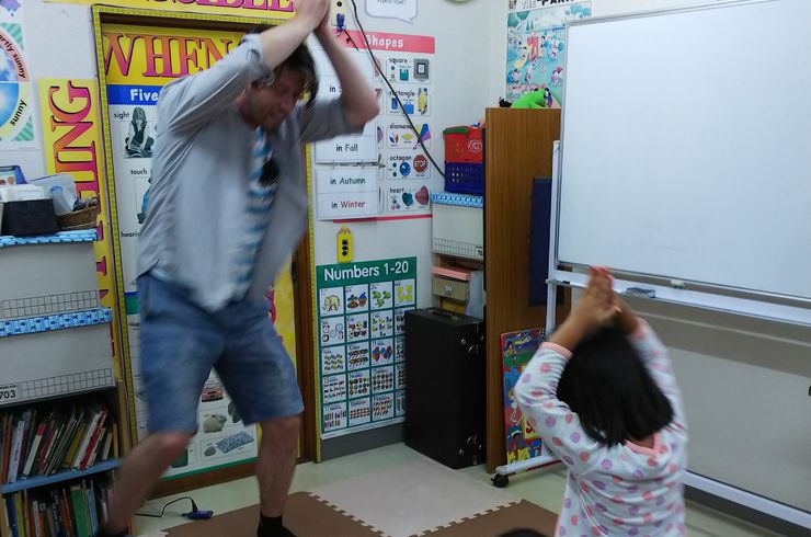 外国人と子どもたちがダンスしている